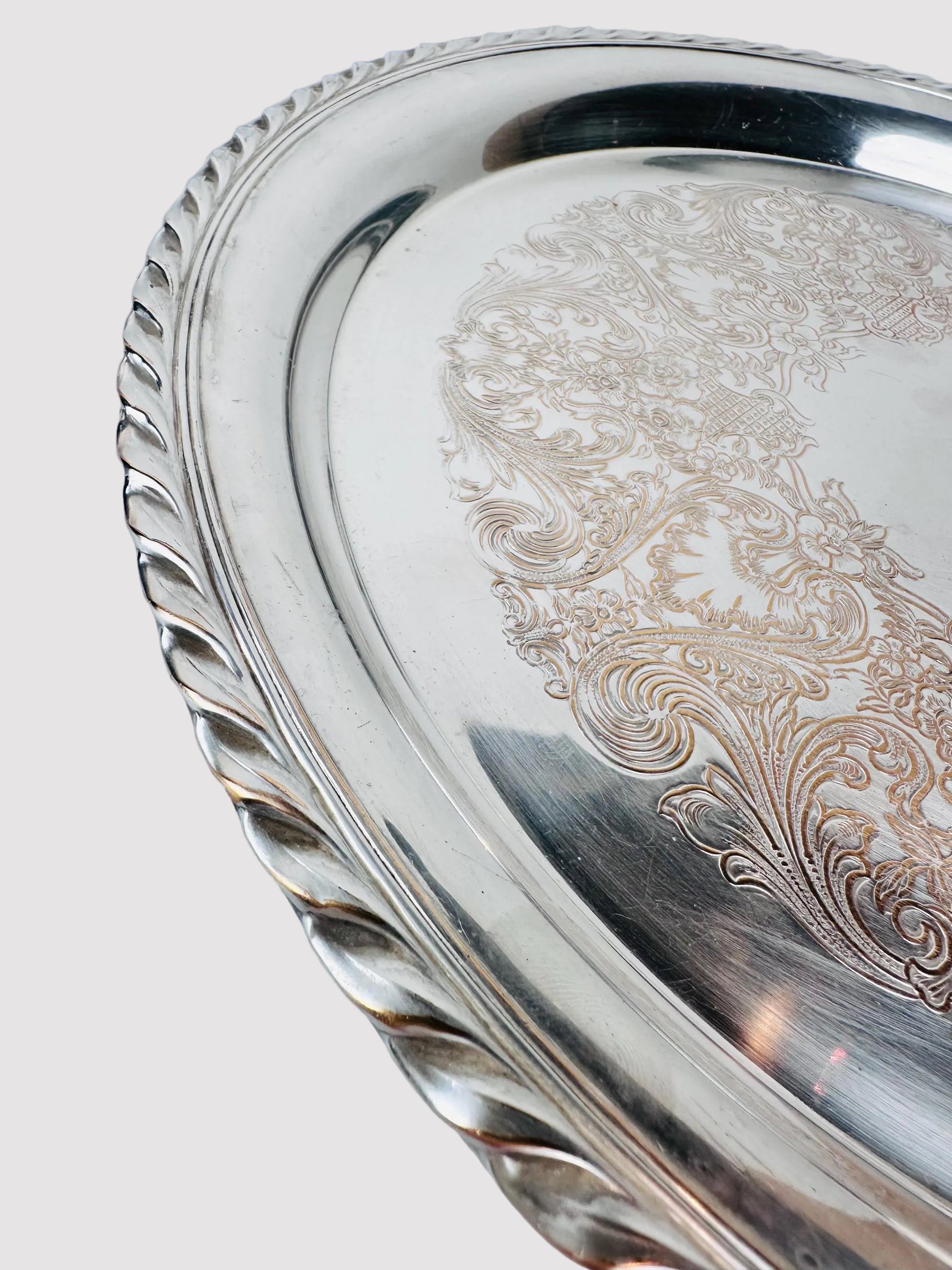 Silver tray with intricate engravings on a marble surface