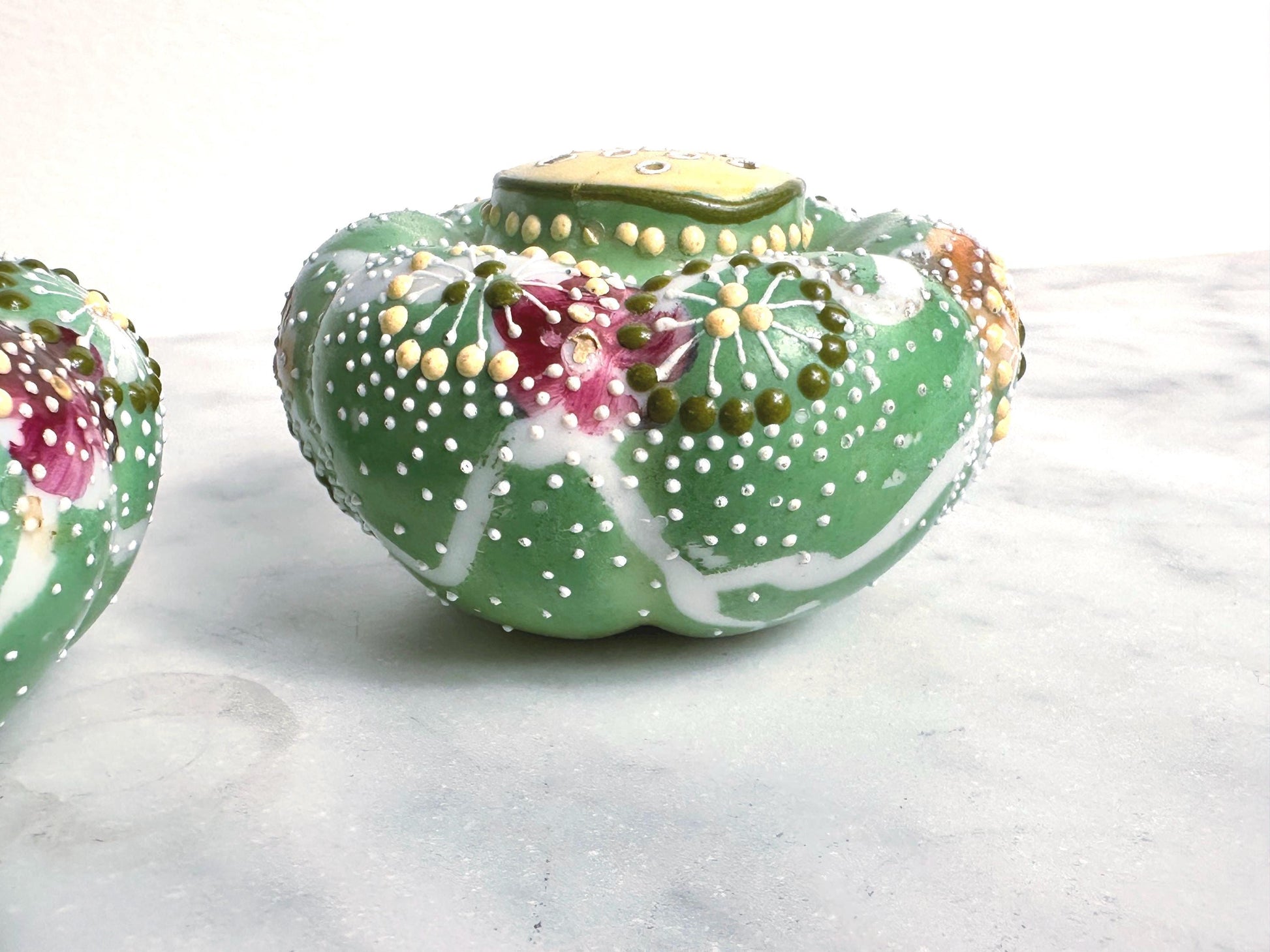 Decorative ceramic pot with floral design on a white surface