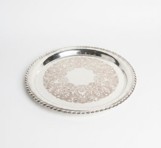 Silver tray with intricate designs on a marble surface