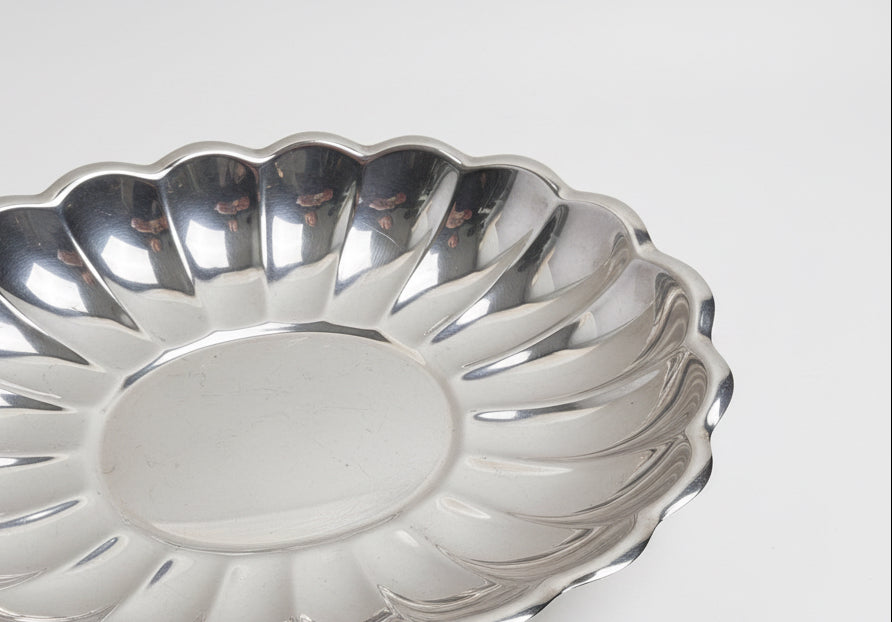 Metallic fluted cake pan on a white surface