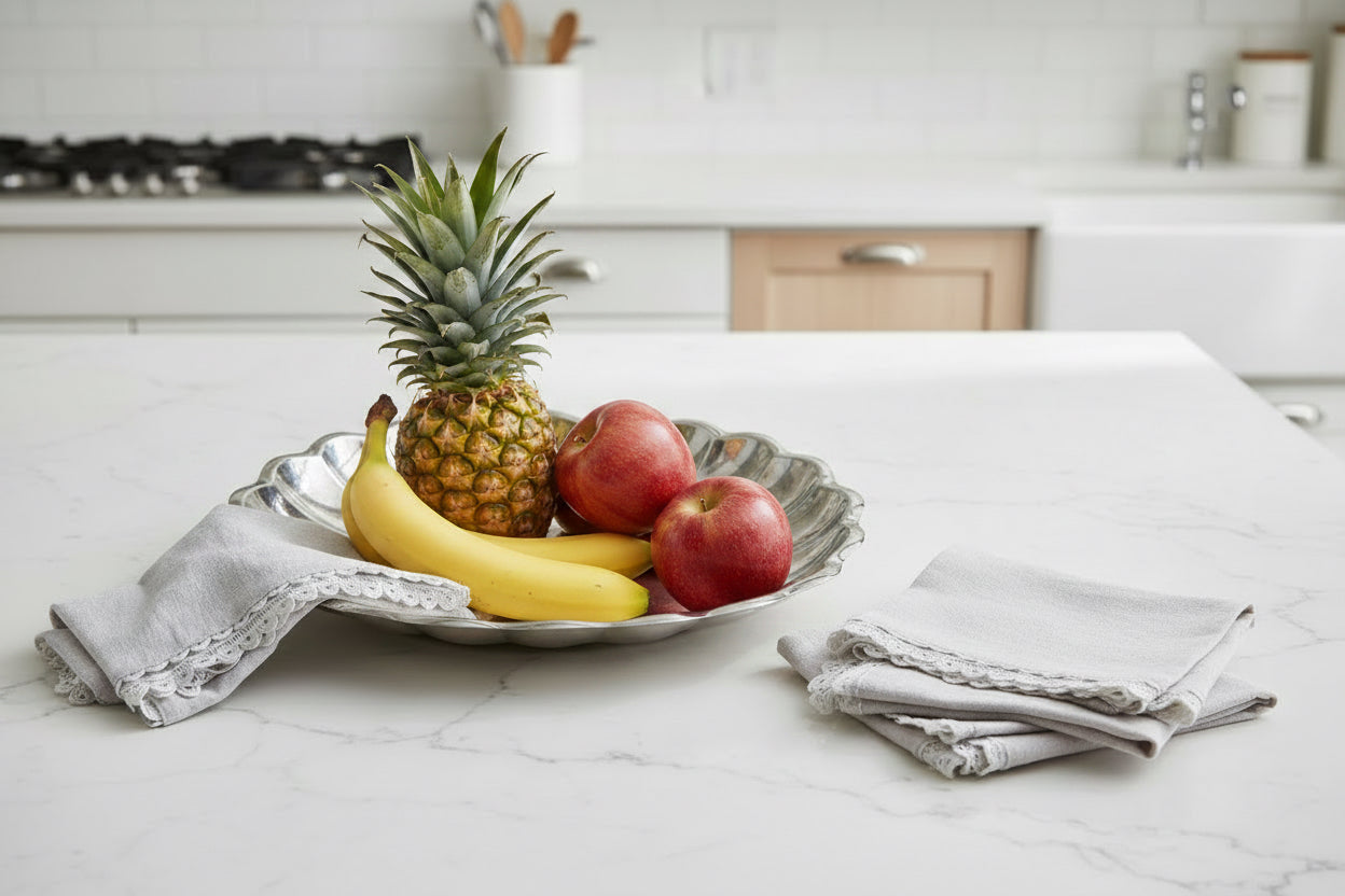 Silver decorative plate on a white surface with a white napkin.