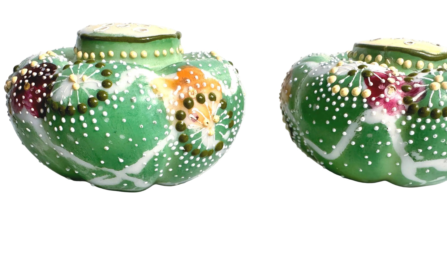 Two decorative ceramic pots with floral patterns on a marble surface