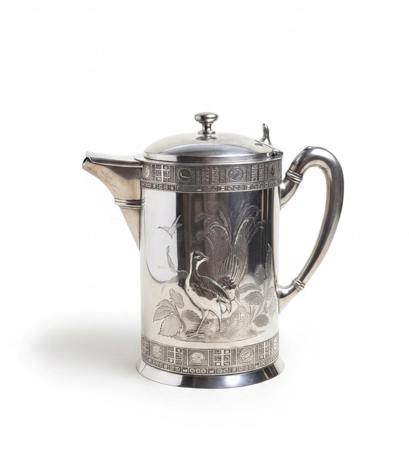 Silver teapot with detailed design on a white surface